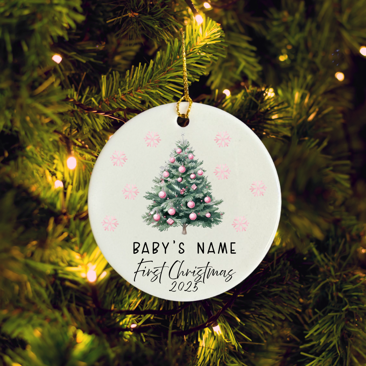 Round Christmas ornament with tree design and text on a lit Christmas tree.