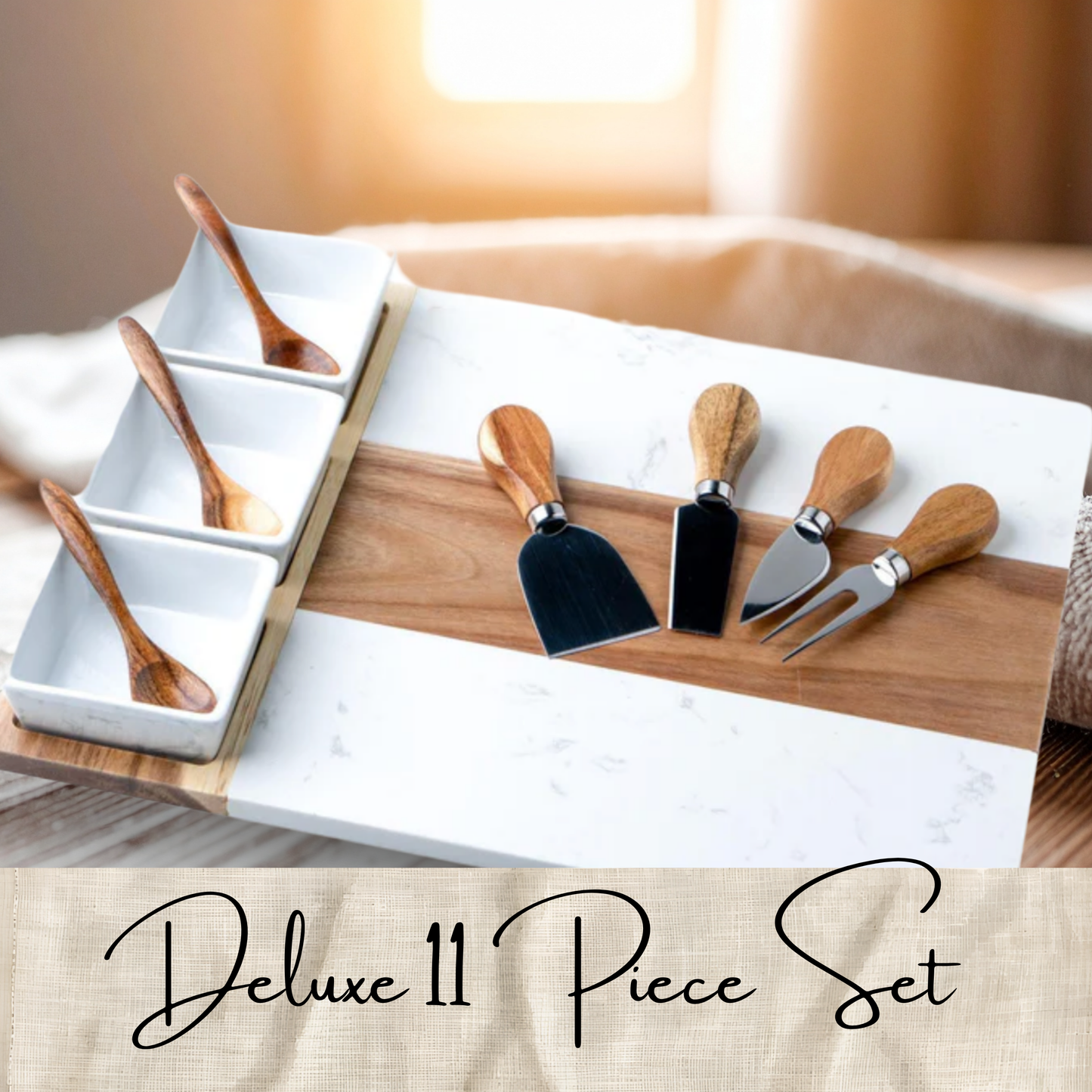 A 11-piece cheese and dip serving set arranged on a white marble board with a wood inlay, including four serving utensils and four small white square dips with wooden spoons. A beige banner at the bottom reads 'Deluxe 11 Piece Set'.