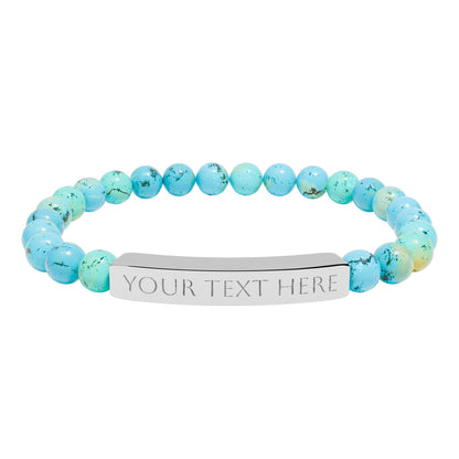 Turquoise beaded bracelet with a customizable silver tag on a white background