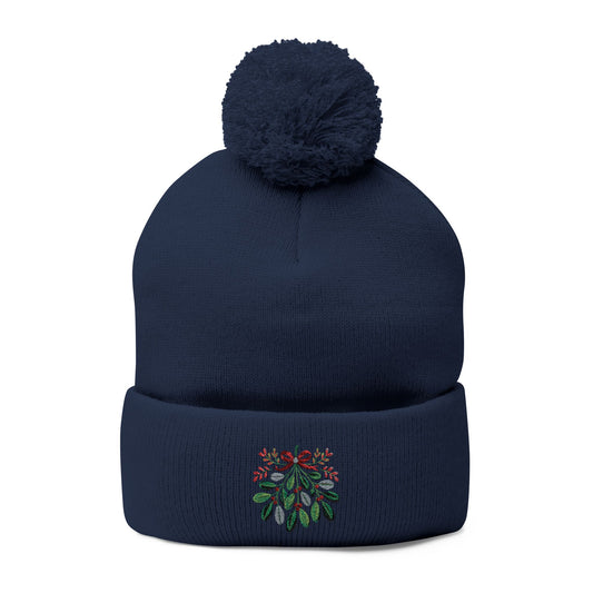 Navy blue beanie with pom-pom and embroidered design on a white background