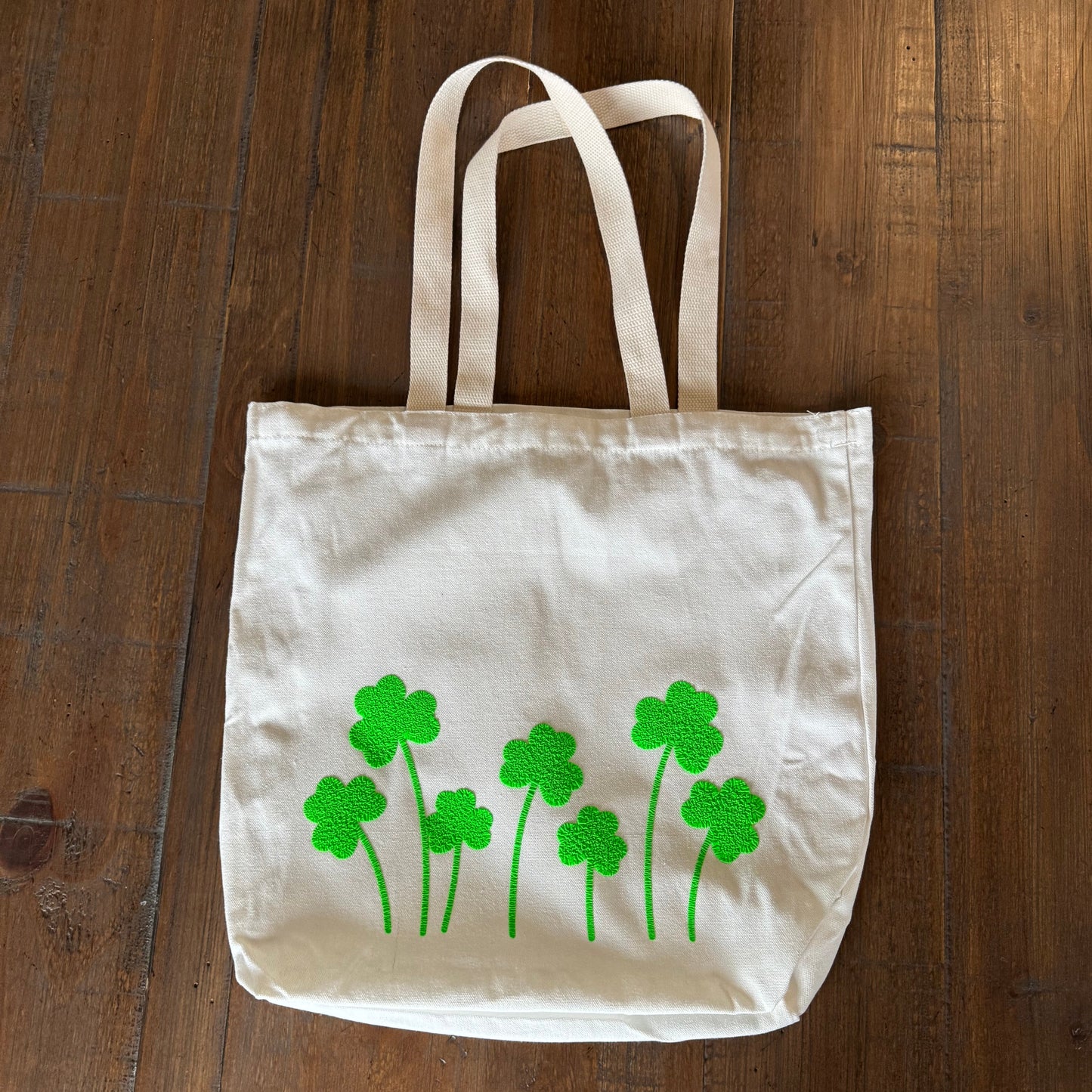 tote bag with green shamrock designs on a wooden surface
