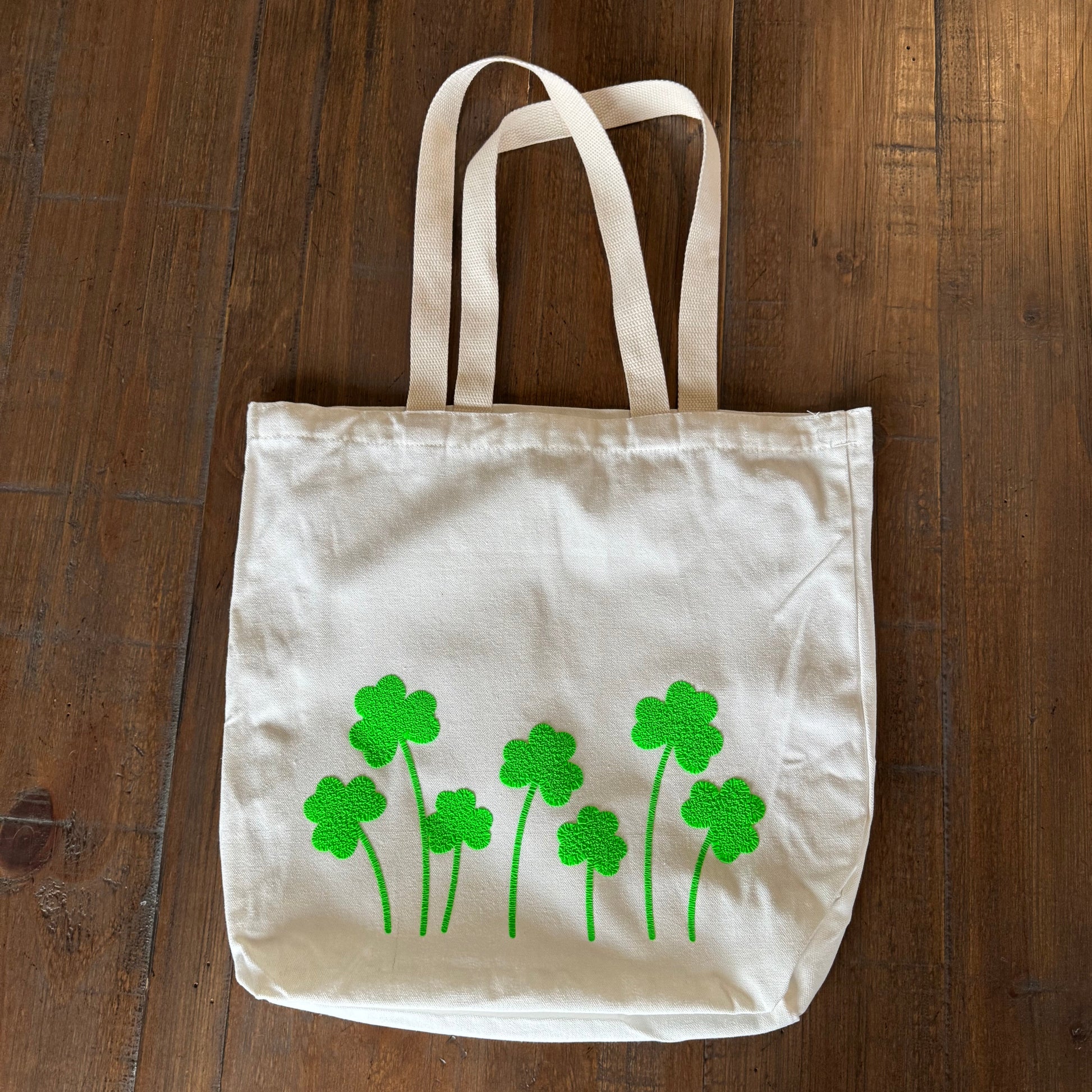 tote bag with green shamrock designs on a wooden surface