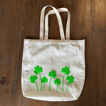 tote bag with green shamrock designs on a wooden surface