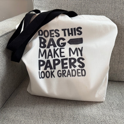 White tote bag with black text on a gray couch
