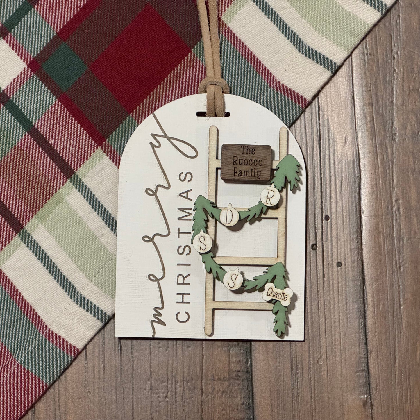 Decorative Christmas tag with ladder design on a plaid fabric background
