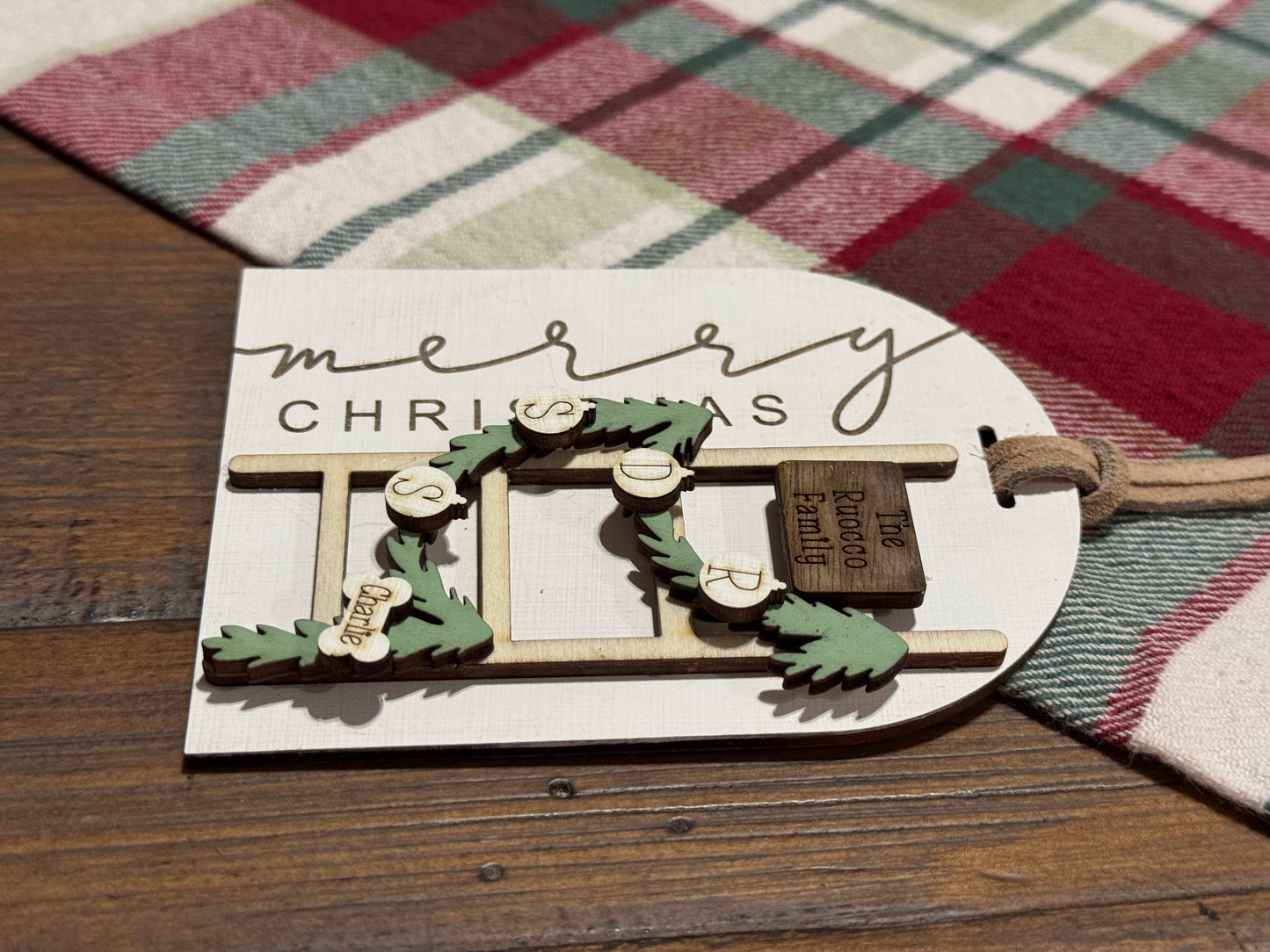 Decorative Christmas tag with wreath design on a plaid fabric background