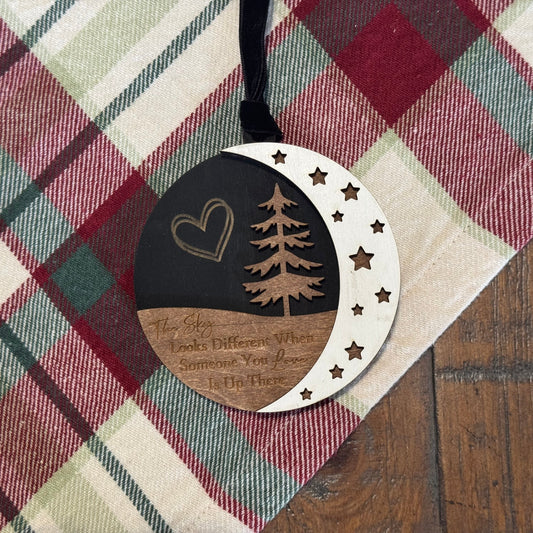 Decorative wooden tag with tree and heart design on a plaid fabric background