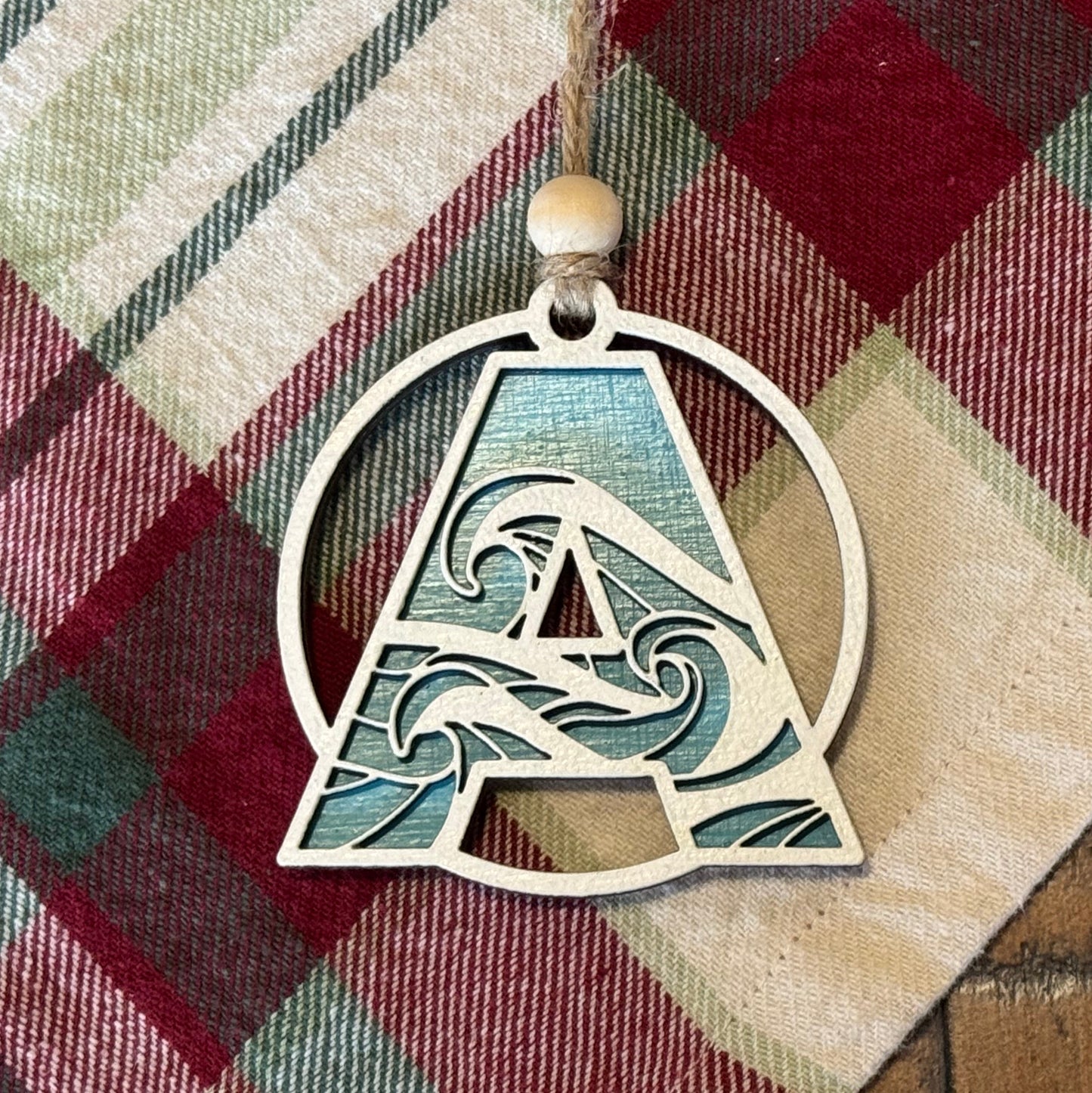 Layered Wave Letter Ornament on a plaid fabric background