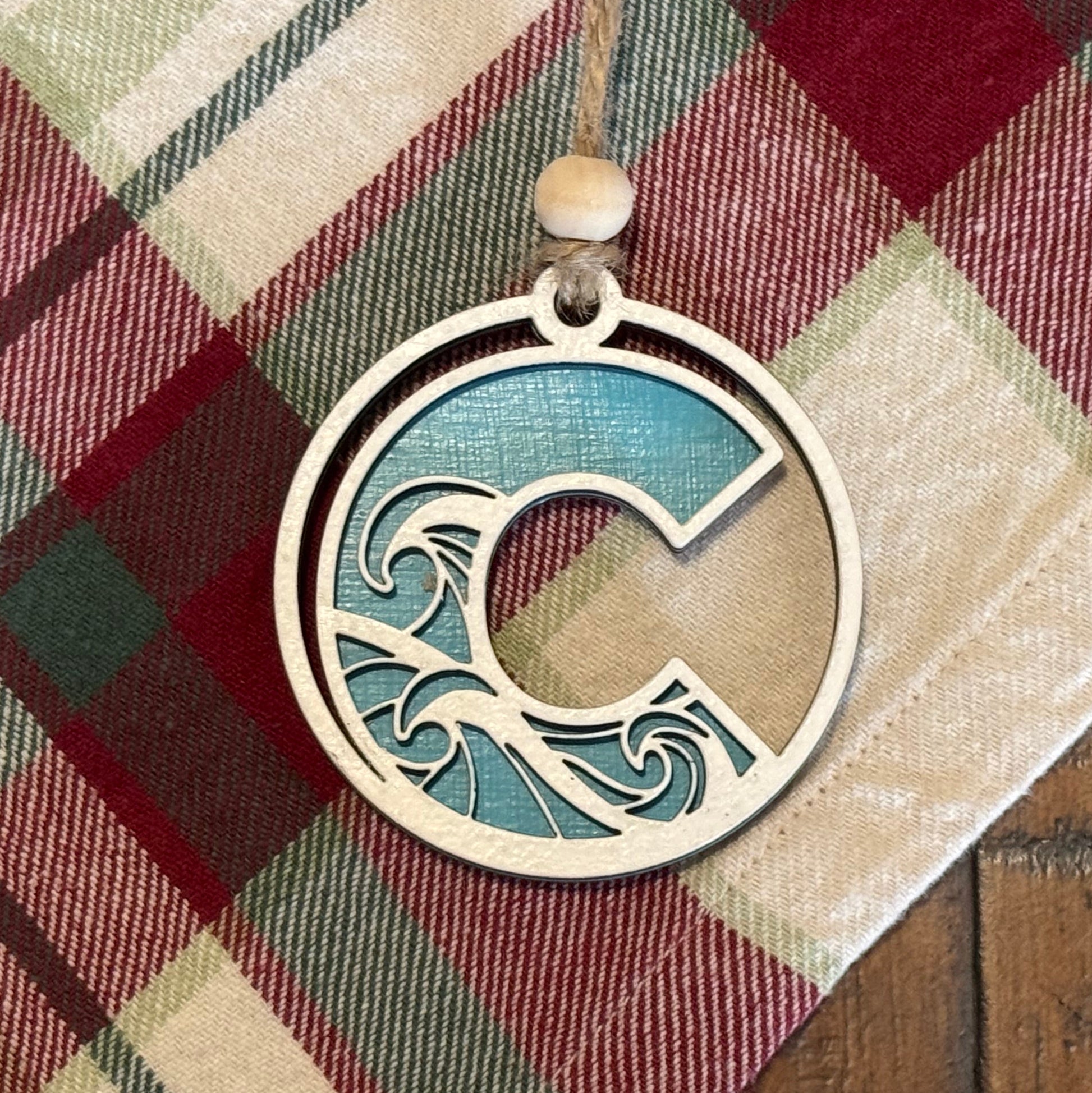 Layered Wave Letter Ornament on a plaid fabric background