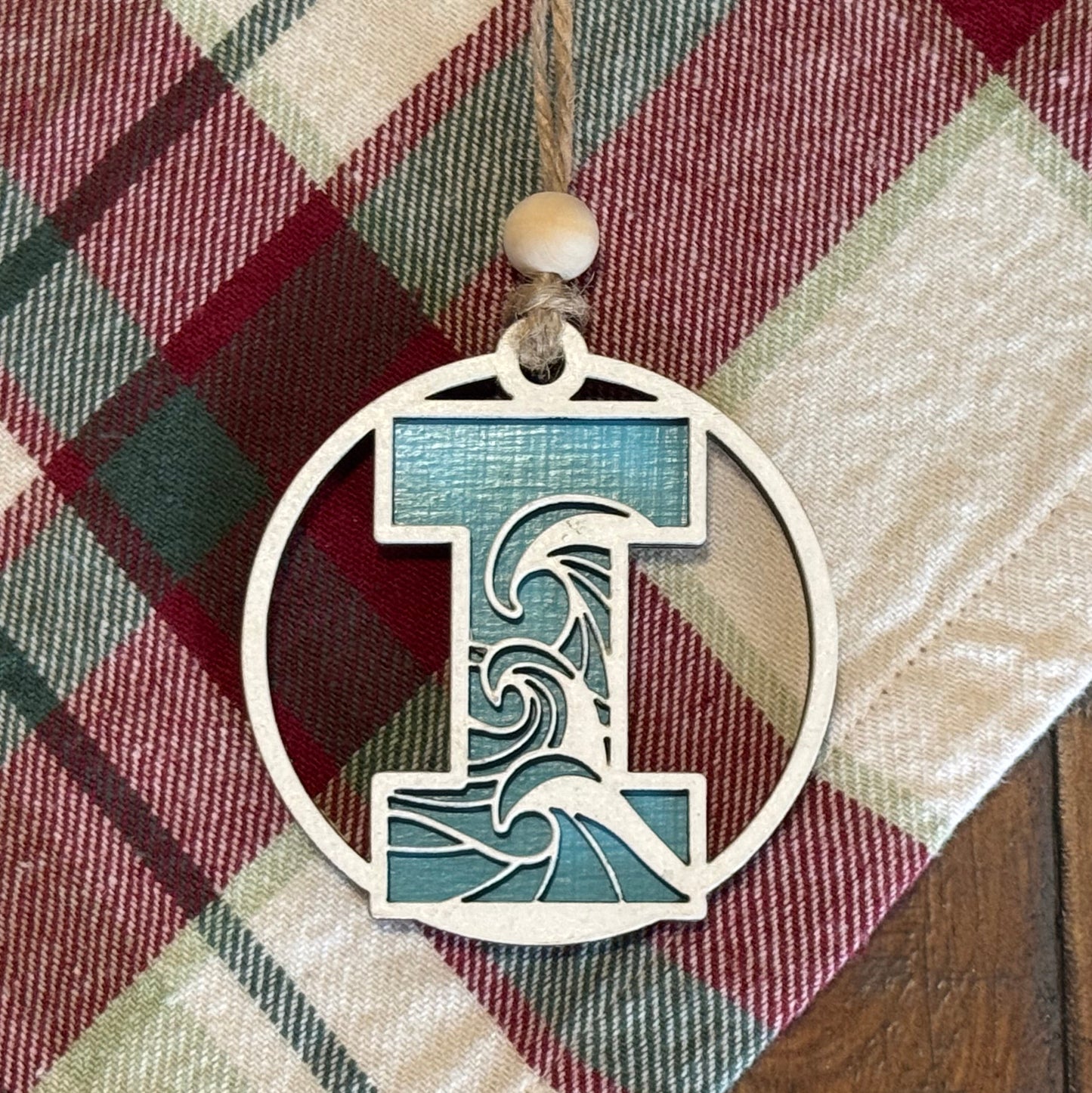 Layered Wave Letter Ornament on a plaid fabric background
