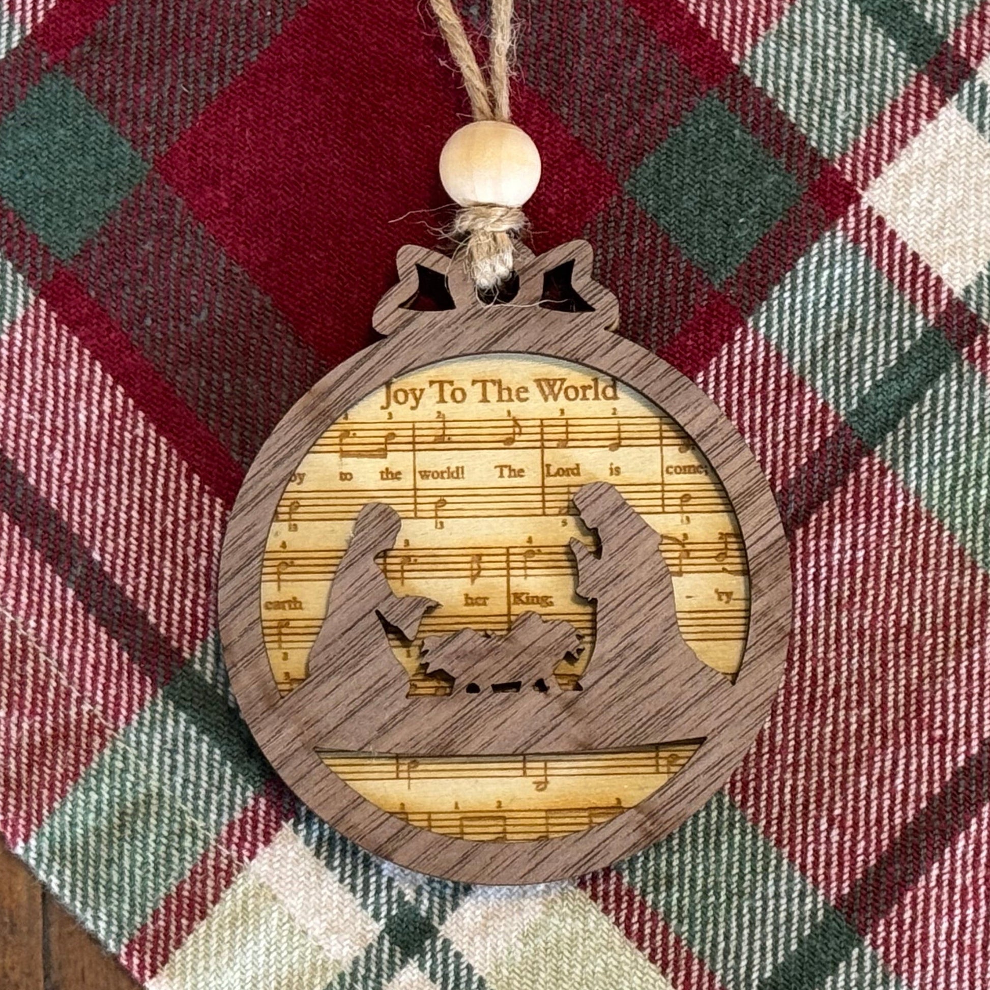 Wooden ornament with musical design on a plaid fabric background