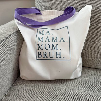 tote bag with purple handles and text on a gray chair