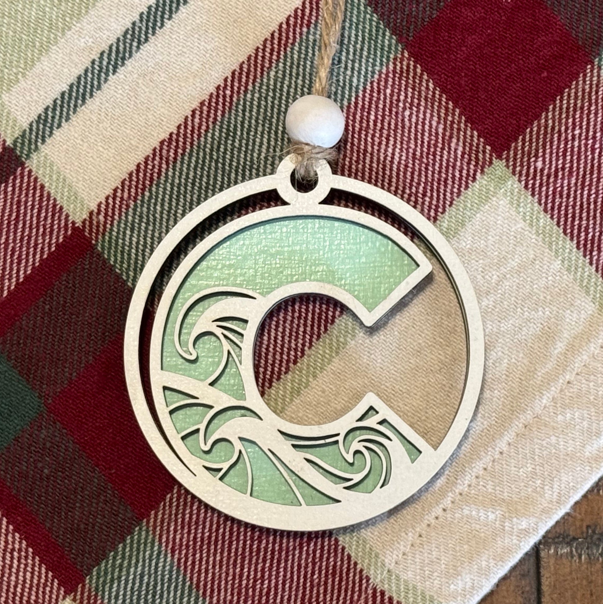 Layered Wave Letter Ornament on a plaid fabric background