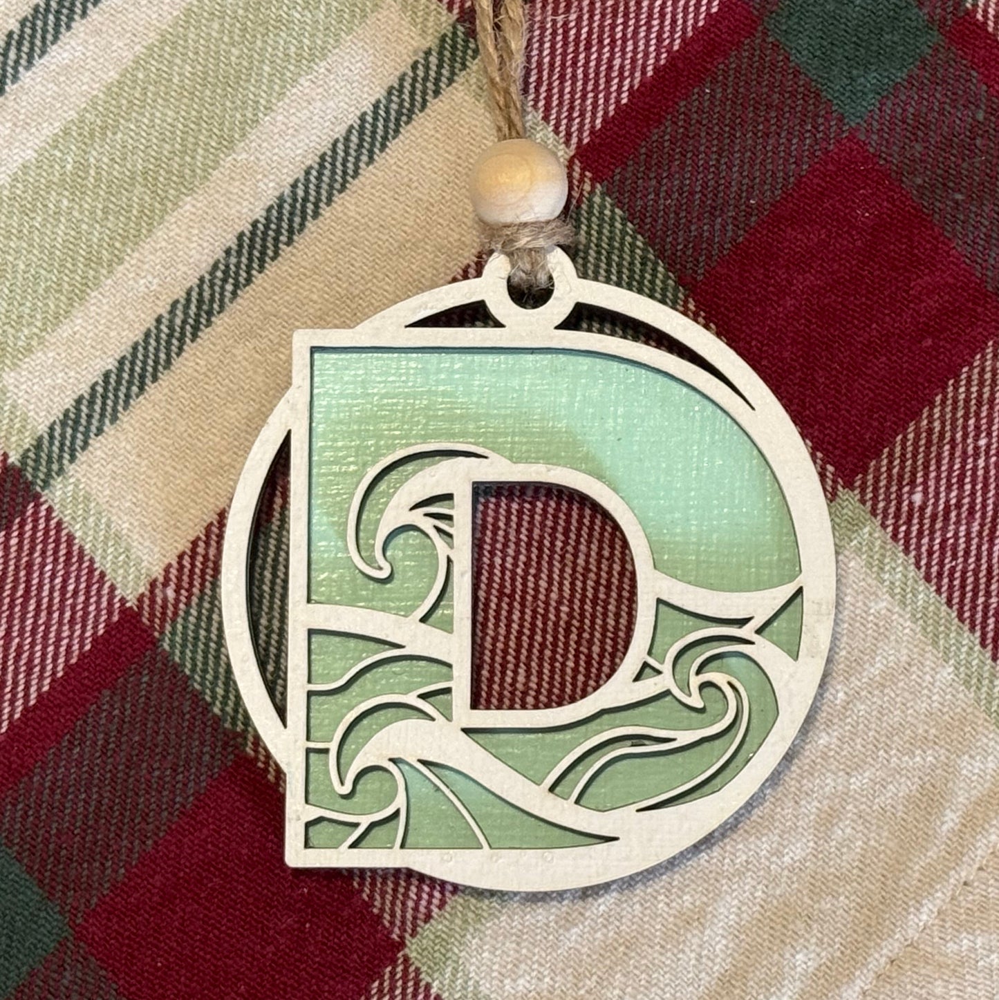 Layered Wave Letter Ornament on a plaid fabric background