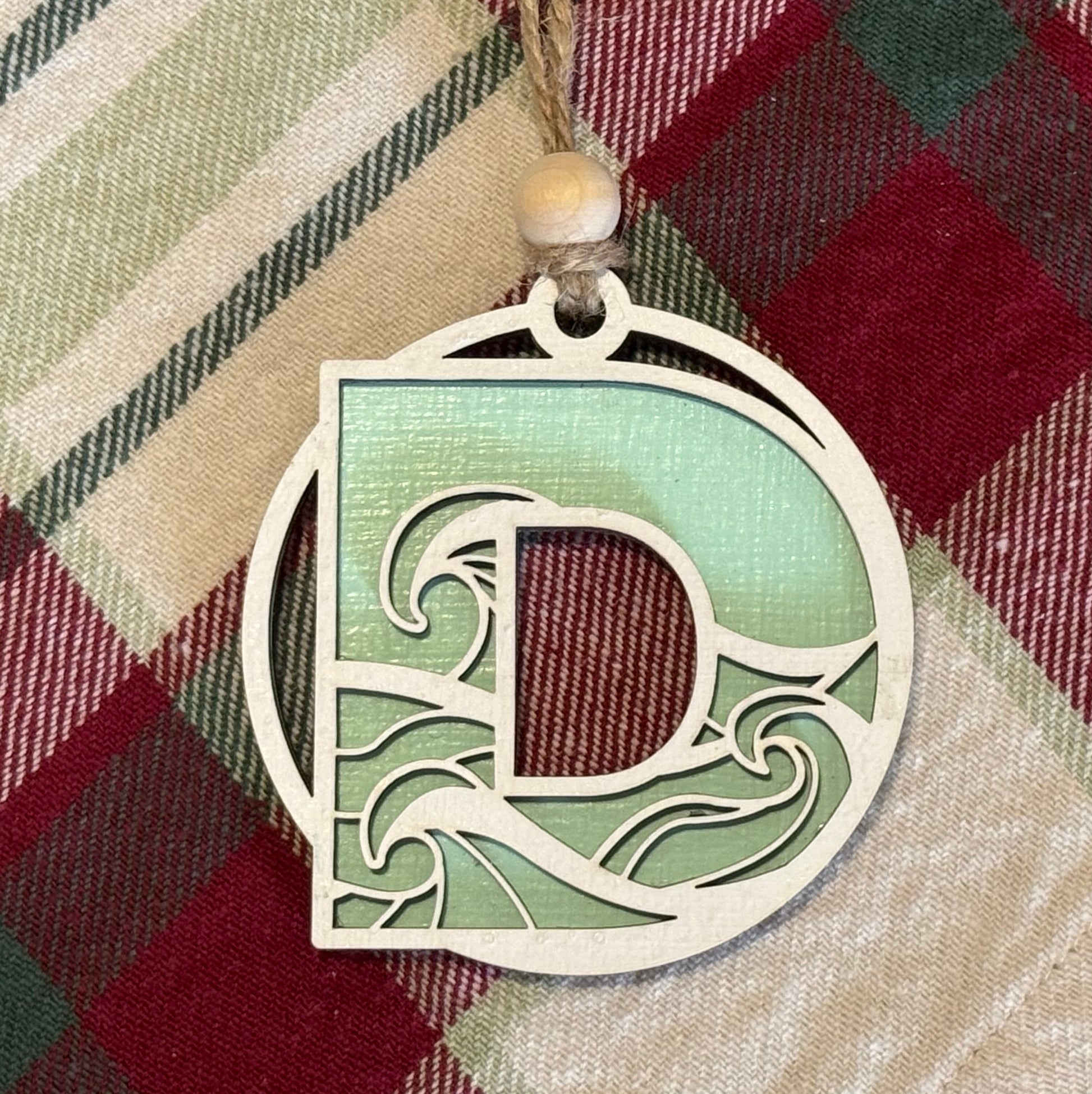 Layered Wave Letter Ornament on a plaid fabric background