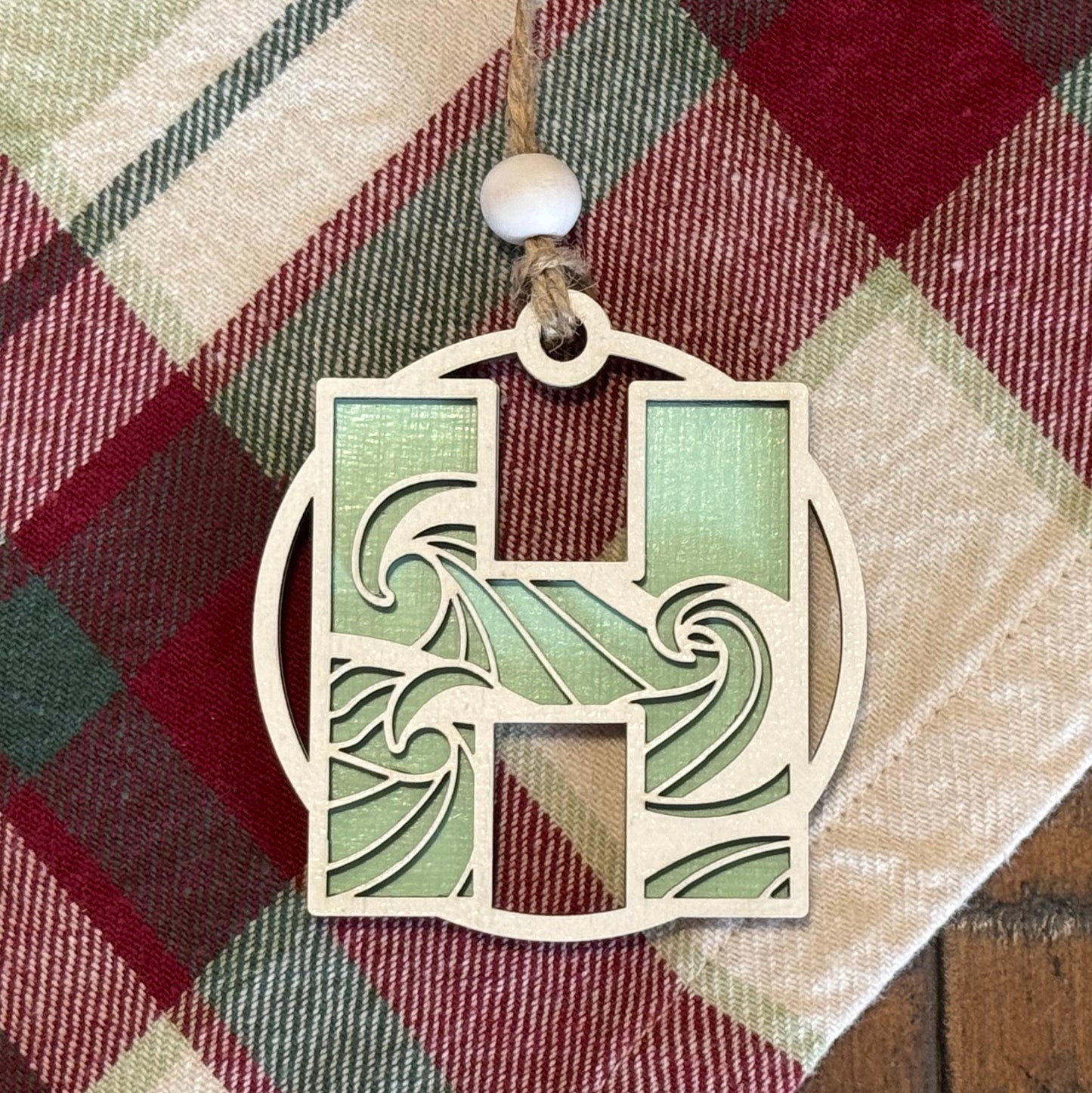 Layered Wave Letter Ornament on a plaid fabric background