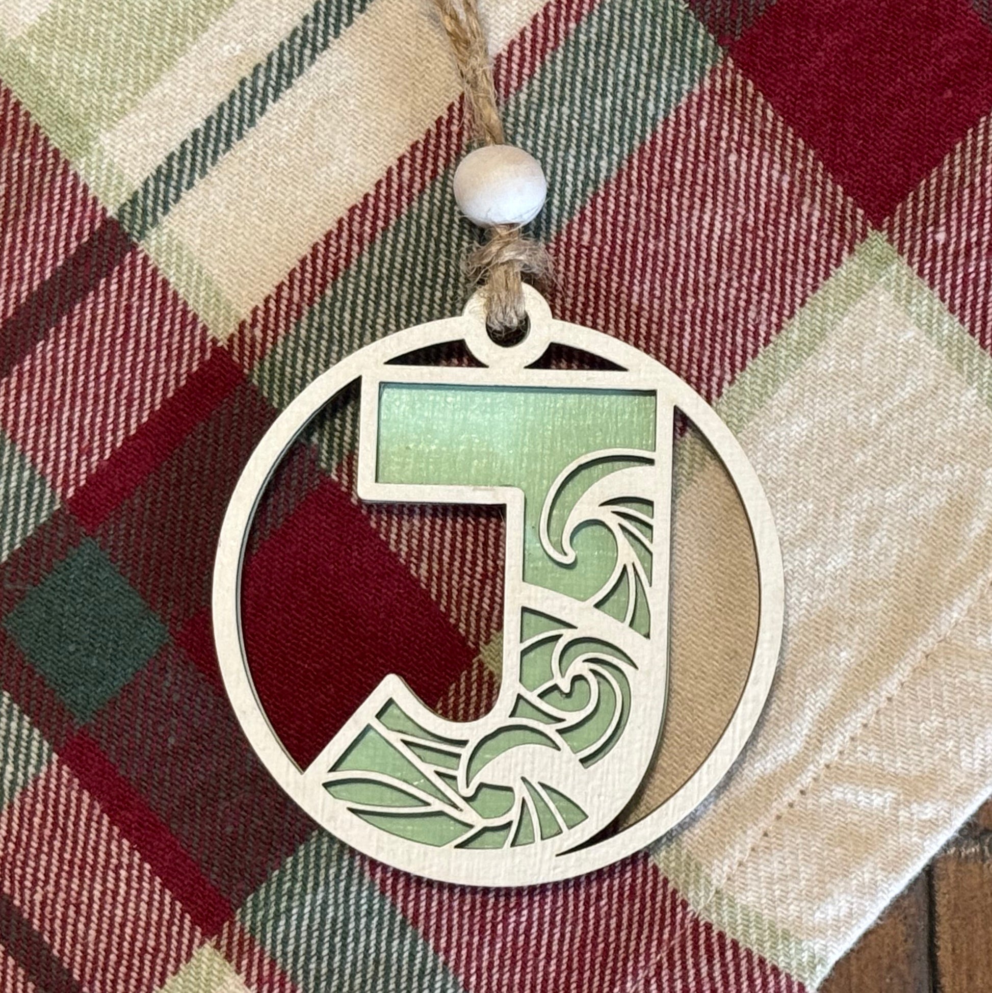 Layered Wave Letter Ornament on a plaid fabric background