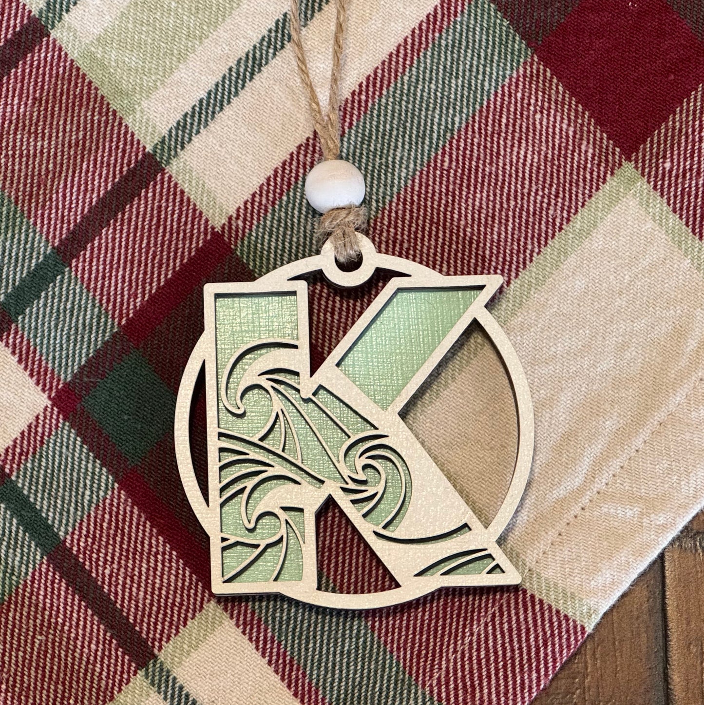 Layered Wave Letter Ornament on a plaid fabric background