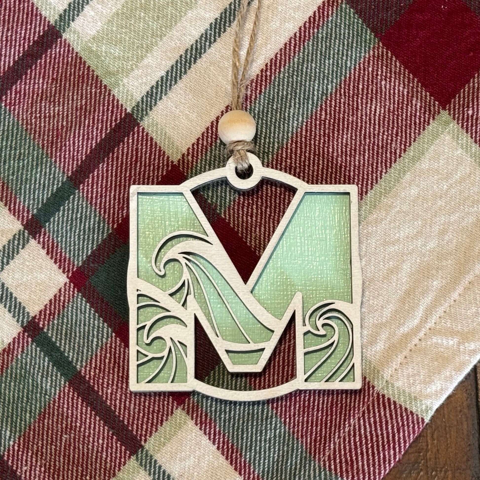Layered Wave Letter Ornament on a plaid fabric background