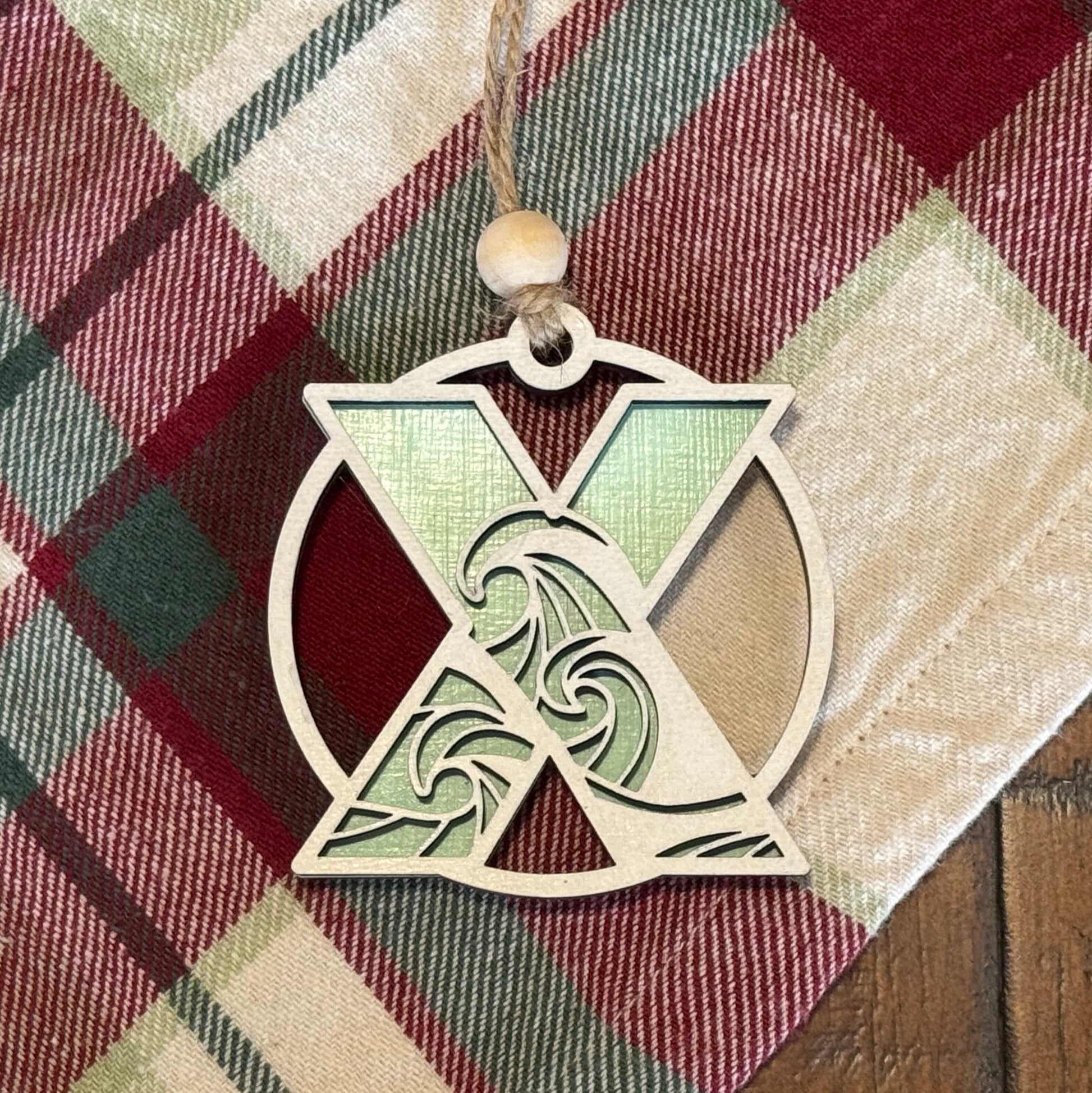 Layered Wave Letter Ornament on a plaid fabric background