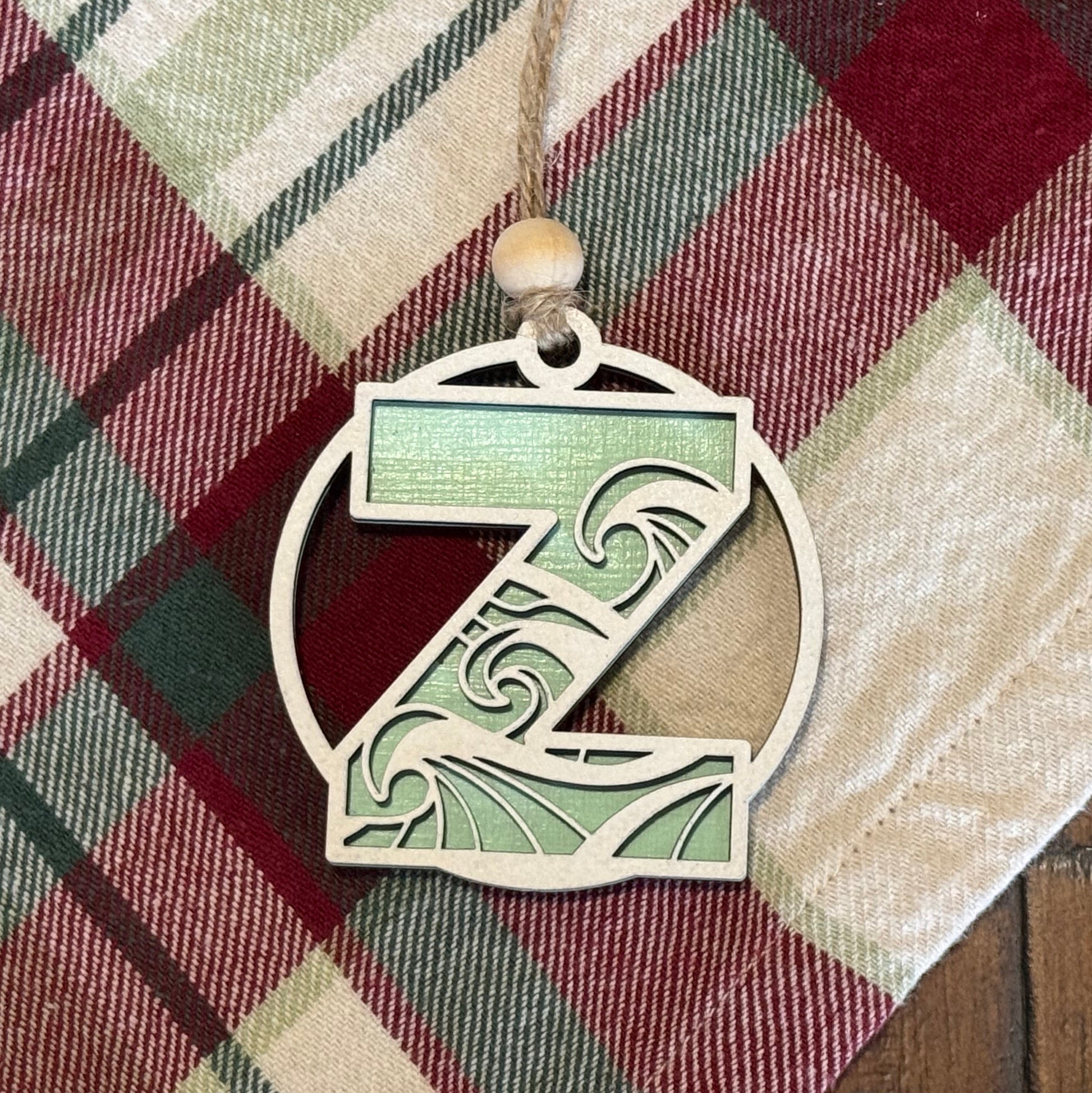 Layered Wave Letter Ornament on a plaid fabric background