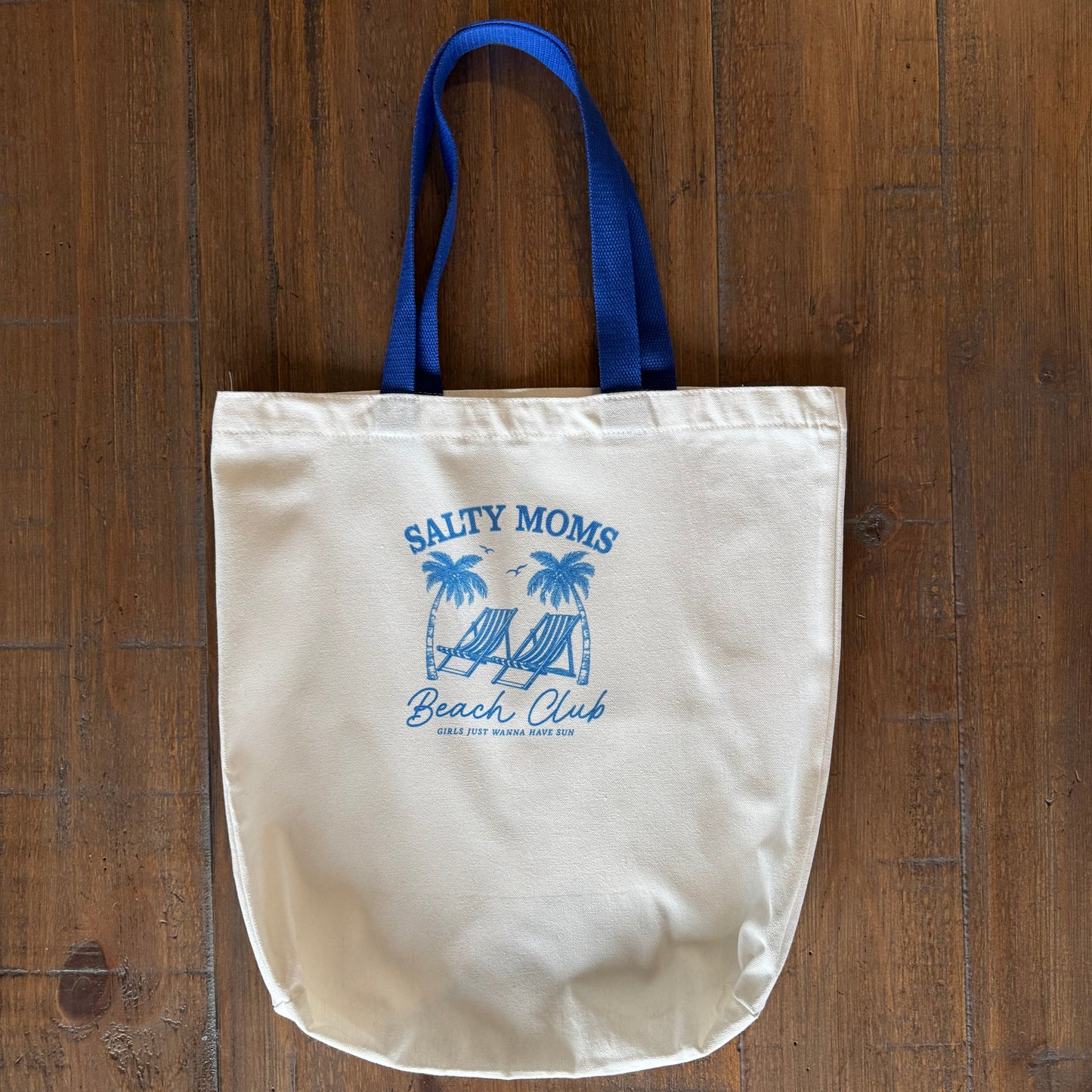tote bag with blue handle and logo on a wooden surface