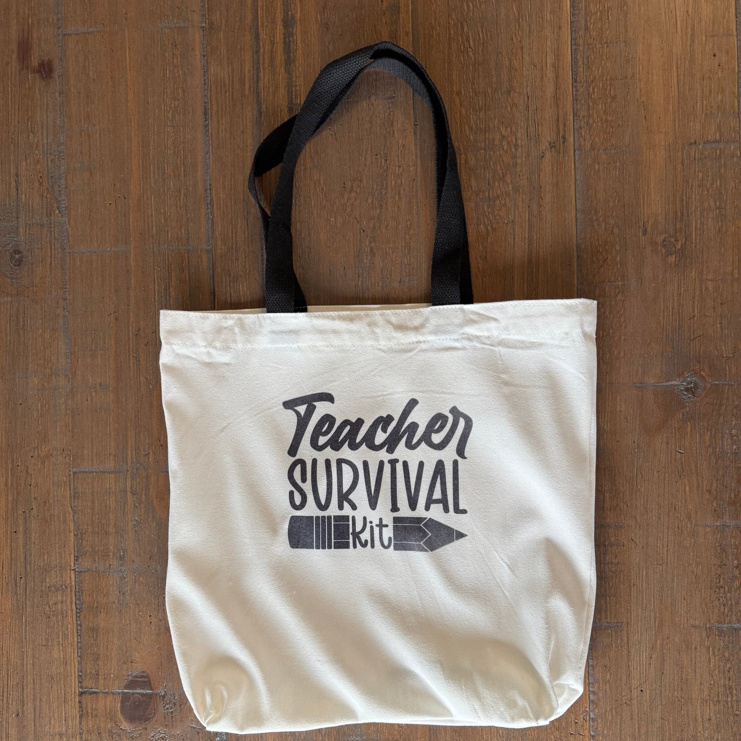 tote bag with 'Teacher Survival Kit' text on a wooden surface